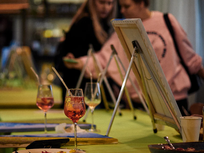 Grupo pintando en atriles con copas de vino